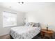 Bright bedroom with a window and neutral decor features a comfortable bed and side table at 14454 Grape Way, Brighton, CO 80602