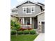 Picturesque front porch with stone columns, American flag, and lush landscaping, offering a warm welcome at 14454 Grape Way, Brighton, CO 80602