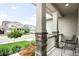 Relaxing front porch view with chairs and a peaceful neighborhood scenery, framed by elegant stone pillars at 14454 Grape Way, Brighton, CO 80602