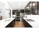 Open-concept kitchen with stainless steel appliances, island with seating, and hardwood flooring at 14454 Grape Way, Brighton, CO 80602