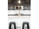 Close-up of kitchen featuring modern faucet and stainless steel microwave, complemented by trendy bar stools at 14454 Grape Way, Brighton, CO 80602