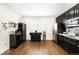 Bright kitchen with stainless steel appliances, dark cabinets, and hardwood floors provides ample storage at 14454 Grape Way, Brighton, CO 80602