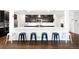 Sleek kitchen featuring a breakfast bar with modern stools, dark cabinets, and stainless steel appliances at 14454 Grape Way, Brighton, CO 80602