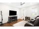 Cozy living room with fireplace, modern ceiling fan, and a comfortable leather couch on hardwood floors at 14454 Grape Way, Brighton, CO 80602