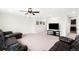 Spacious living room with a ceiling fan, neutral carpet and a large tv at 14454 Grape Way, Brighton, CO 80602