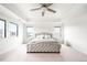 Bright, neutral bedroom offers a tufted king bed, carpet, and plenty of natural light at 14454 Grape Way, Brighton, CO 80602
