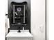 Stylish powder room featuring a black framed mirror and modern black faucet at 14454 Grape Way, Brighton, CO 80602