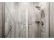 Contemporary shower featuring sleek wood-look tile, a glass door, and modern fixtures at 14454 Grape Way, Brighton, CO 80602