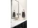 Close up of bathroom vanity featuring granite countertops, new faucet and a framed mirror at 14454 Grape Way, Brighton, CO 80602