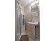 Downstairs bathroom with walk-in shower, pedestal sink, cabinet, updated fixtures and tile floor at 338 Chelsea St, Castle Rock, CO 80104