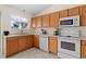 Well-lit kitchen featuring white appliances, oak cabinets, and a window bringing in natural light at 338 Chelsea St, Castle Rock, CO 80104