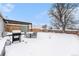 Winter backyard featuring a barbecue and patio furniture covered in snow at 11 S Perry St, Denver, CO 80219