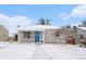 Charming single-story home featuring a covered porch, blue door with wreath, and snow-covered yard at 11 S Perry St, Denver, CO 80219