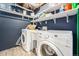 Well-lit laundry room with a wash sink, modern washing machine and dryer at 11 S Perry St, Denver, CO 80219