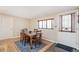 Dining room boasts a wooden table and chairs with an area rug, door, and large window at 2252 Lamar St, Edgewater, CO 80214