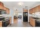 Functional kitchen featuring wood cabinets, modern appliances, and hardwood floors transitioning to the living room at 2252 Lamar St, Edgewater, CO 80214