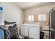 Bright laundry room featuring a washer, dryer, and natural light from a window at 2252 Lamar St, Edgewater, CO 80214