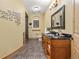 Bathroom with custom wooden vanity, granite countertop, tile floor, and decorative wall art at 7398 Weaver Cir, Castle Rock, CO 80104