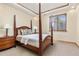 Bedroom with a four-poster bed, tray ceiling, side table and soft neutral colors and carpet at 7398 Weaver Cir, Castle Rock, CO 80104