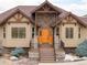 Inviting home with wood front door, stone accents, and manicured shrubs at 7398 Weaver Cir, Castle Rock, CO 80104