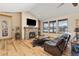 Cozy living room featuring a stone fireplace, wood floors, and natural light at 7398 Weaver Cir, Castle Rock, CO 80104