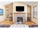 Warm living room with a stone fireplace, wood floors, and neutral tones at 7398 Weaver Cir, Castle Rock, CO 80104
