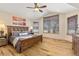 This is the main bedroom with hardwood floors, a ceiling fan, wooden furniture, and three windows at 7398 Weaver Cir, Castle Rock, CO 80104