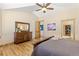 This is the main bedroom featuring hardwood floors, ceiling fan, dresser and views into the walk-in closet at 7398 Weaver Cir, Castle Rock, CO 80104