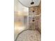 This shower stall is composed of brown tile and features two shower heads behind a frosted glass partition at 7398 Weaver Cir, Castle Rock, CO 80104