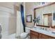 Clean bathroom featuring a vanity with granite countertops, framed mirror, and a bathtub with a shower at 4285 Corte Bella Dr, Broomfield, CO 80023