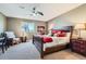 Cozy bedroom with plush carpet, ample natural light from a large window, and a ceiling fan at 4285 Corte Bella Dr, Broomfield, CO 80023