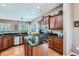 Well-lit kitchen showcasing wooden cabinets, stainless steel appliances, and granite countertops and a large island at 4285 Corte Bella Dr, Broomfield, CO 80023