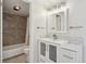 Updated bathroom features a vanity, framed mirror, modern lighting, and a shower over the tub at 540 S Forest St # 3-204, Denver, CO 80246