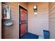 Close-up of the red front door with black trim, unit number, and decorative hanging planter at 540 S Forest St # 3-204, Denver, CO 80246