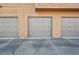 Exterior view of garages featuring gray doors and wood siding at 540 S Forest St # 3-204, Denver, CO 80246