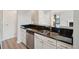 Efficient kitchen with stainless steel appliances, white cabinets, and a black countertop with a double sink at 540 S Forest St # 3-204, Denver, CO 80246