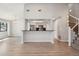 Open-concept living space with hardwood floors and views of the kitchen and staircase at 540 S Forest St # 3-204, Denver, CO 80246