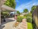 Inviting backyard featuring a covered patio, lush lawn, stone pathway, manicured landscaping, and a charming greenhouse at 6810 S Marion W Cir, Centennial, CO 80122