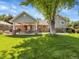 Spacious backyard with covered patio, outdoor dining area, lush lawn, mature trees, and a charming swing at 6810 S Marion W Cir, Centennial, CO 80122