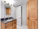 Bathroom featuring wood cabinets, granite countertop vanity and a mirror at 6810 S Marion W Cir, Centennial, CO 80122