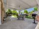 Relaxing covered patio with an outdoor dining area, ceiling fan, and views of the landscaped backyard at 6810 S Marion W Cir, Centennial, CO 80122