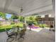 Wonderful covered patio featuring an outdoor dining set, ceiling fan, grill, and lush backyard views at 6810 S Marion W Cir, Centennial, CO 80122