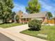 Inviting two-story home with a spacious driveway, lush green lawn, and mature trees providing shade and curb appeal at 6810 S Marion W Cir, Centennial, CO 80122