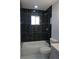 Stylish bathroom featuring black tile surround, white tub, white toilet, and gray vanity at 9191 Russell Way, Thornton, CO 80229