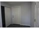 Clean entryway with a white front door, closet, neutral paint, and dark tile flooring at 9191 Russell Way, Thornton, CO 80229