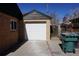 Single car detached garage with white door, concrete driveway and brick accents at 9191 Russell Way, Thornton, CO 80229
