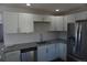 Bright kitchen featuring stainless steel appliances, granite counters and modern white cabinets at 9191 Russell Way, Thornton, CO 80229