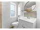 Bathroom featuring a vanity with cabinets, a toilet, and a window for natural light at 1535 Hudson St # 1, Denver, CO 80220