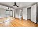This bedroom features a ceiling fan, hardwood floors, and a mirrored wall with natural light from the window at 1535 Hudson St # 1, Denver, CO 80220