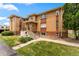 Well-maintained brick apartment building featuring a front lawn, stairs, and ample parking at 1535 Hudson St # 1, Denver, CO 80220